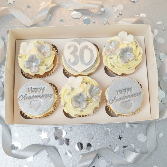 Elegant anniversary cupcakes with silver toppers and sugarpaste flowers for delivery in Basildon Essex
