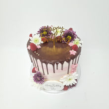 Load image into Gallery viewer, A beautifully decorated white buttercream cake with a pink chocolate drip, topped with fresh berries and delicate flowers, perfect for elegant celebrations.