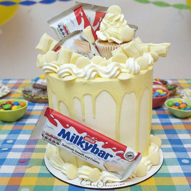 Milky Bar Chocolate Drip Cake with smooth white chocolate drip, buttercream swirls, and Milky Bar chocolates, handmade and personalised, perfect for birthdays and special occasions, available for delivery in Basildon and Essex.