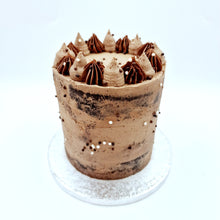 Load image into Gallery viewer, A semi-naked cake features layers of fluffy sponge, adorned with a light buttercream coating, revealing hints of the cake beneath.
