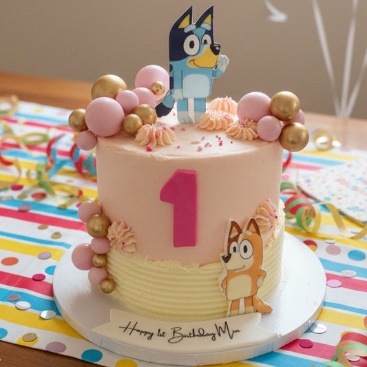 Bluey Themed Birthday Cake with Bluey and Chilli images on smooth pink buttercream, handmade and customisable to blue, perfect for children’s birthdays and Bluey fans, available for delivery in Basildon and Essex.