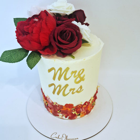 Wedding cake with red and white roses and 'Mr & Mrs' text on a white background