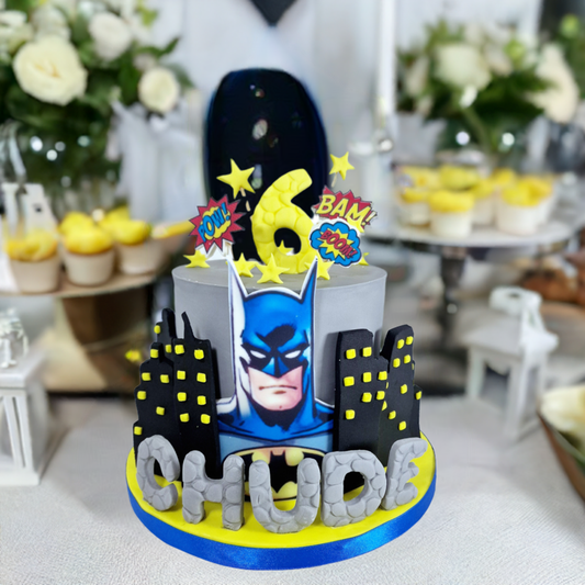 A themed birthday cake decorated to look like the Batman character, with a cityscape background.