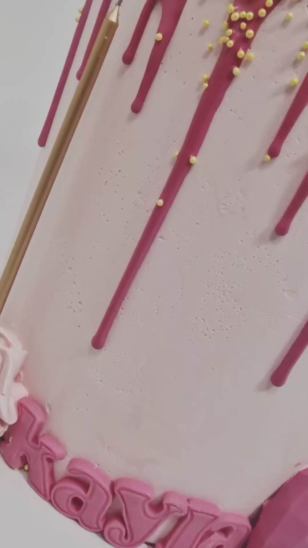 Pretty in Pink Celebration Cake with smooth baby pink buttercream, hot pink drip, cupcake topper, mini hearts, chocolates, and golden candle, handmade and personalised, perfect for birthdays, anniversaries, and special celebrations, available for delivery in Basildon and Essex.