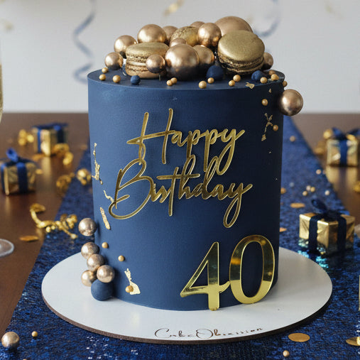 Navy blue cake with golden macaroons and decorative balls made in Basildon Essex