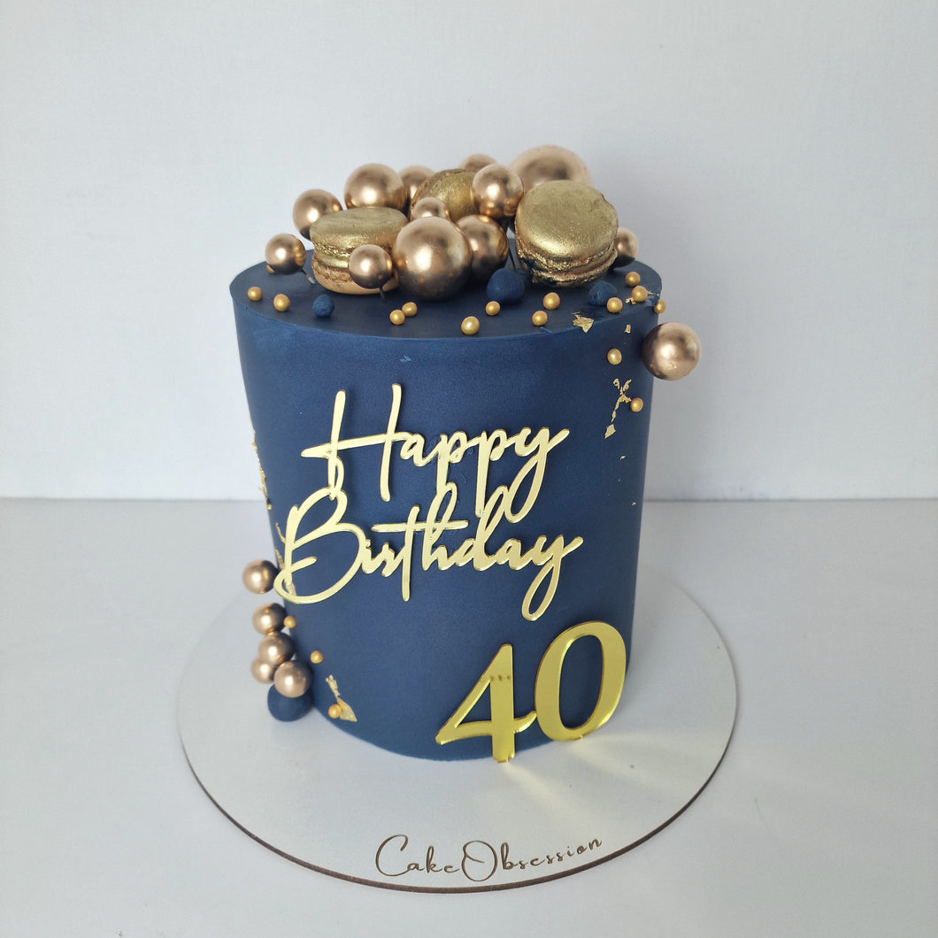 Indulge in our exquisite navy blue cake, beautifully adorned with golden macaroons and decorative golden balls. 
