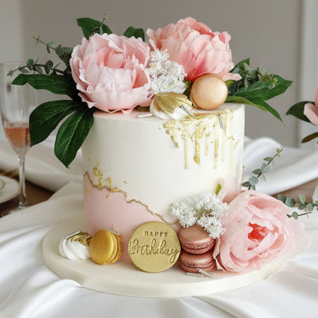 elegant white and pink fondant cake with gold edges, silk flowers, macarons and white chocolate drip, cake delivery Basildon Essex